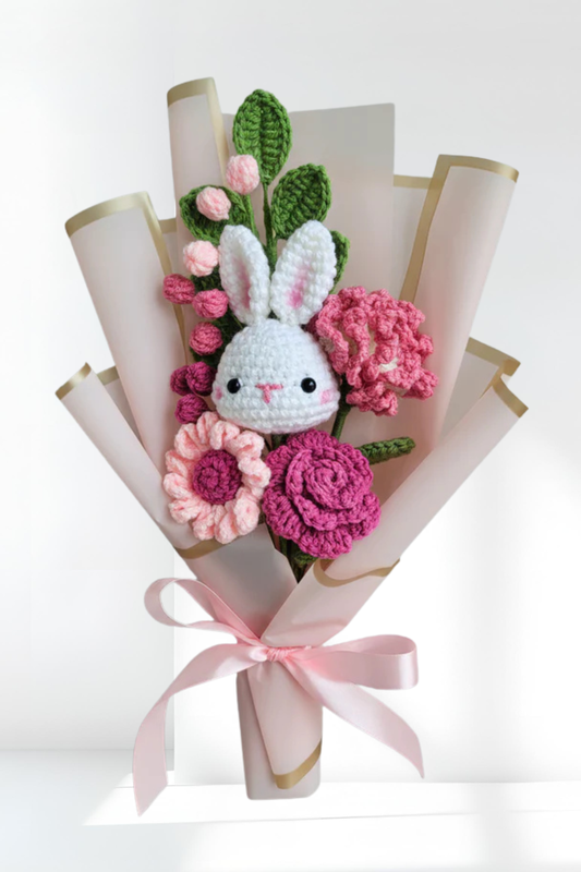 Bouquet of crocheted flowers with a bunny face in the center on a white background