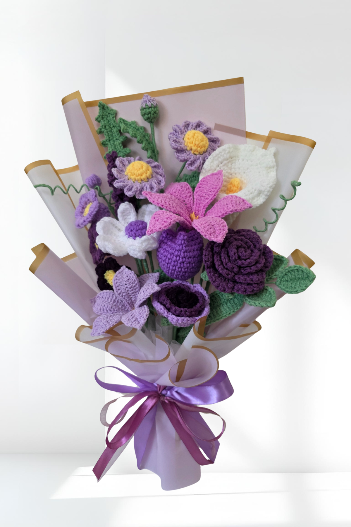 Crochet flower bouquet with a purple ribbon on a white background