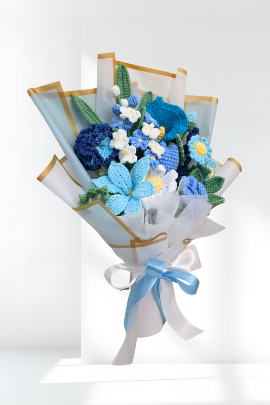 Bouquet of blue and white flowers wrapped in paper with a ribbon on a white background