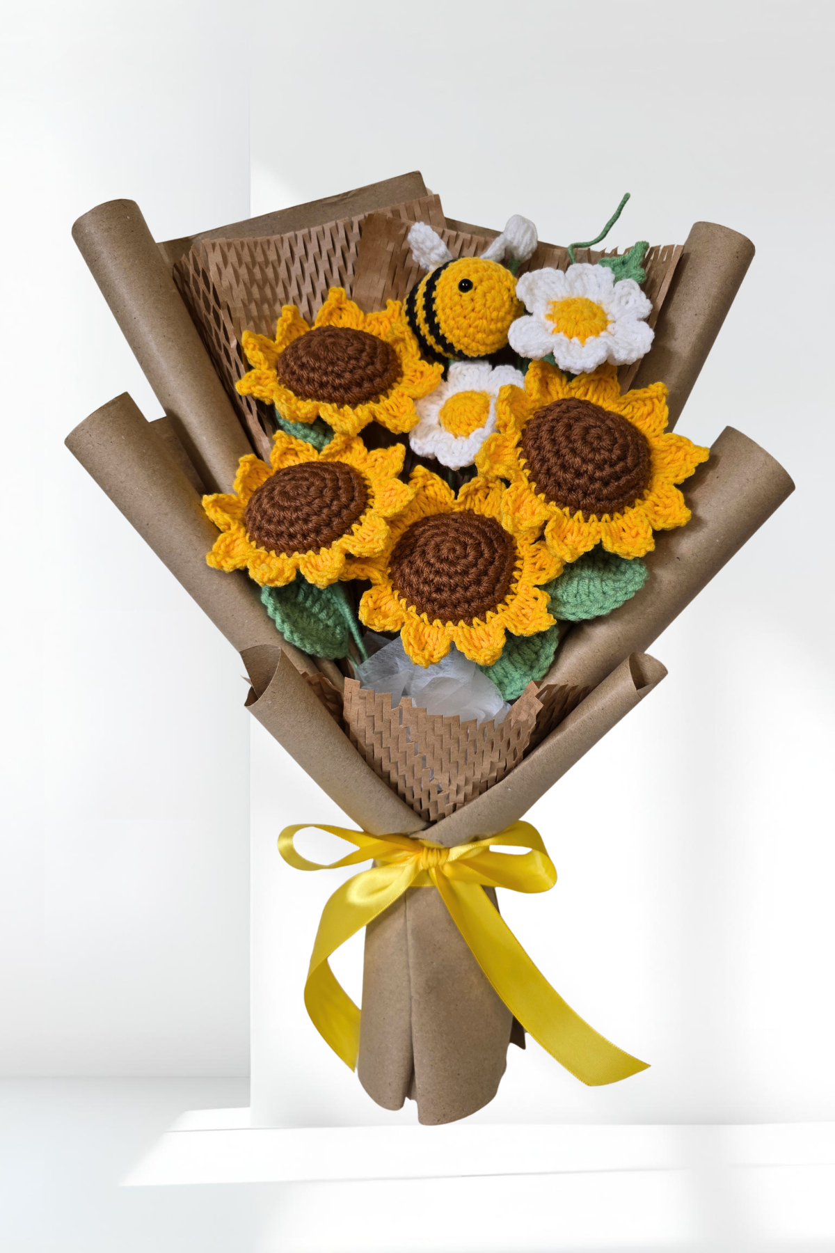 Bouquet of crocheted sunflowers and a bee on a white background