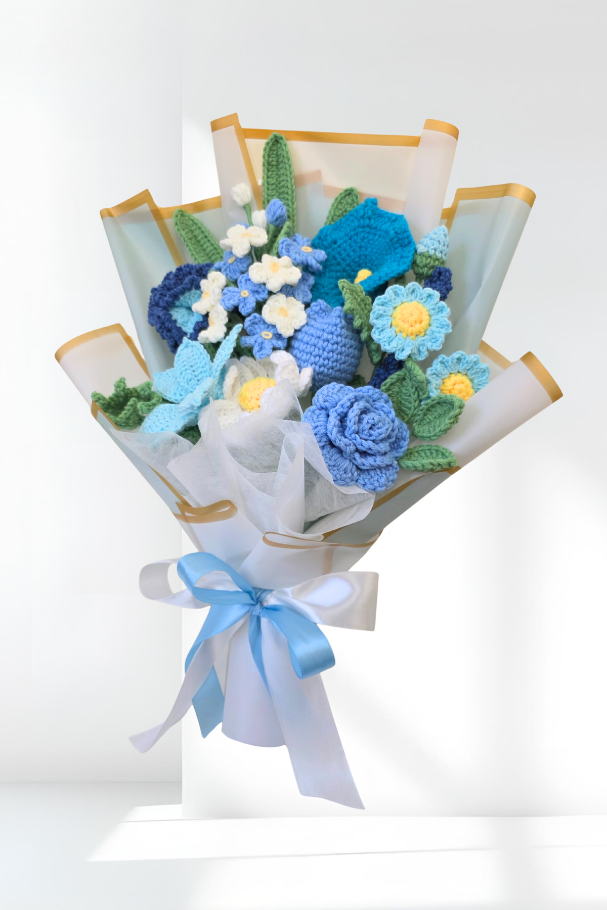 Bouquet of knitted flowers with blue and green colors on a white background