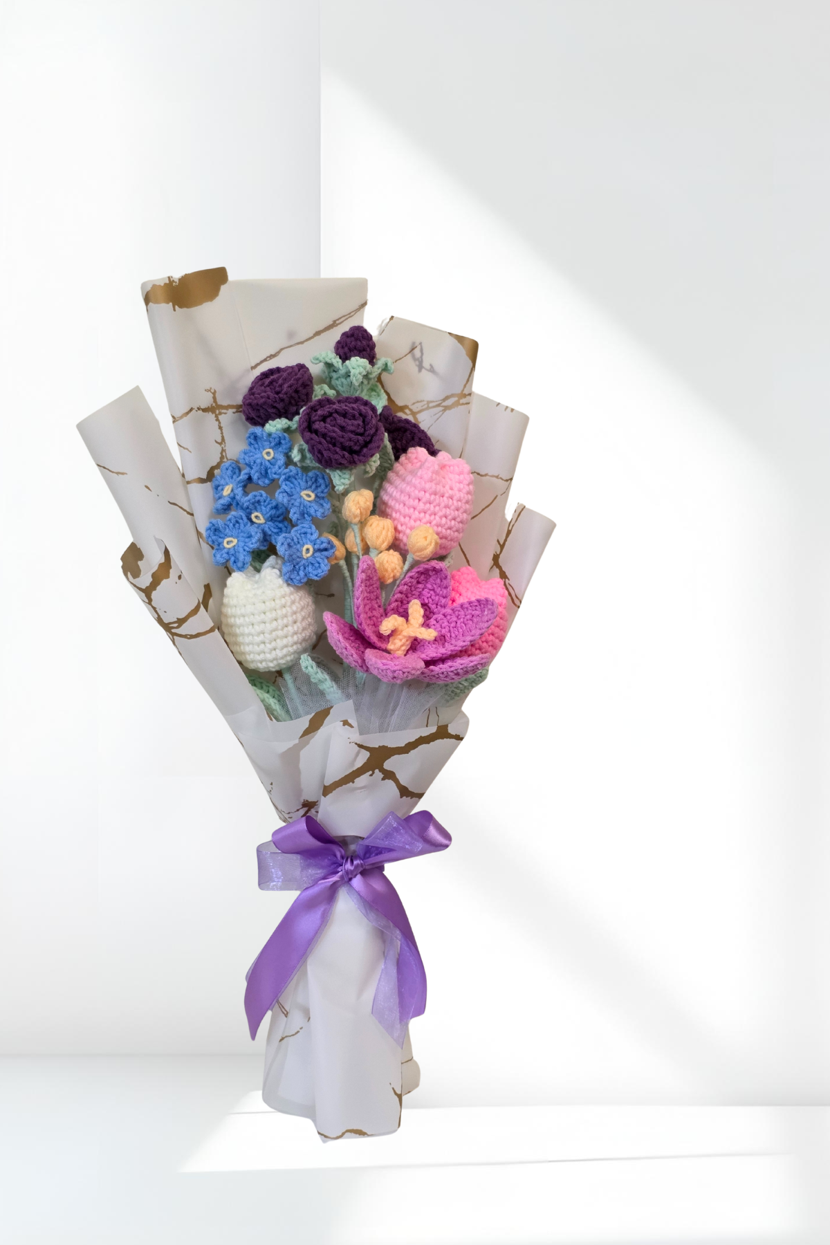 A charming blend of purple roses, blue blossoms, and soft pastel tulips