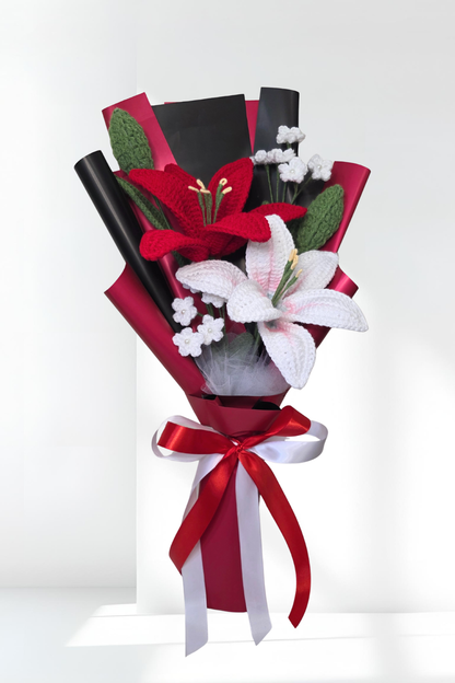 lily bouquet with red and white flowers wrapped in black paper and ribbon on a white background