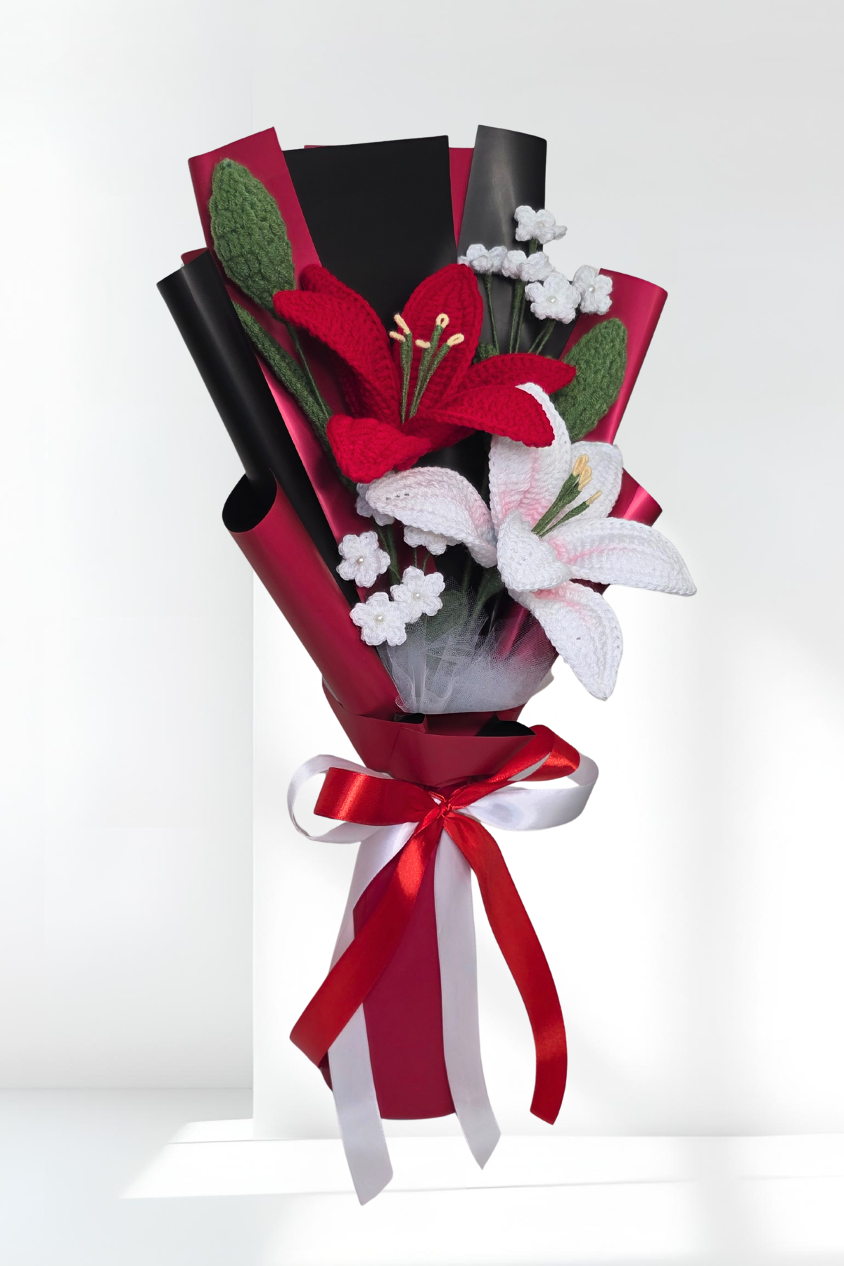 lily bouquet of red and white flowers with a red ribbon on a white background