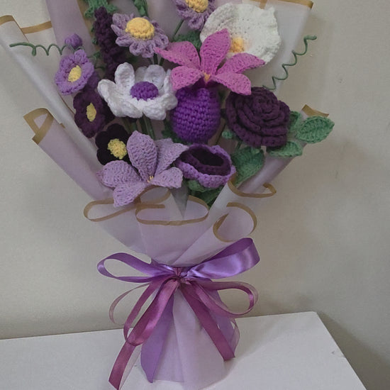 crochet flower bouquet with a purple ribbon on a white background